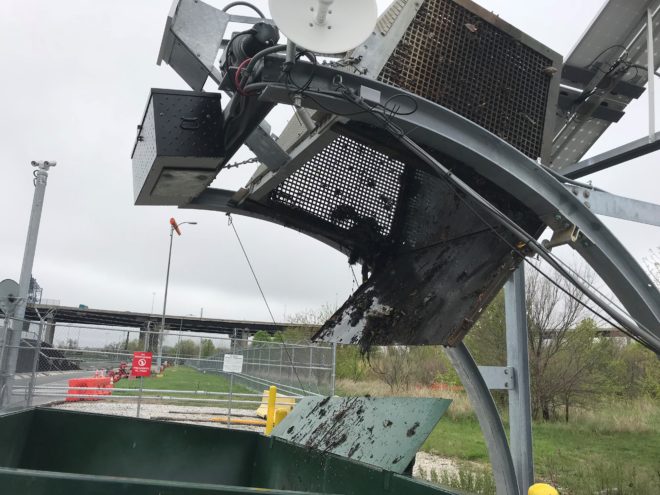 TED empties trash into a dumpster