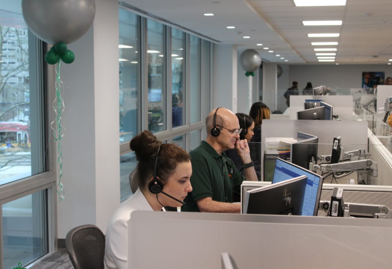 Call center employees at work station by window
