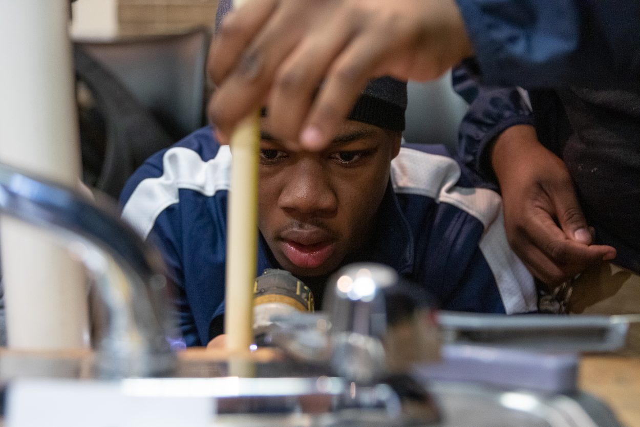 Mervo plumbing student examines pipe
