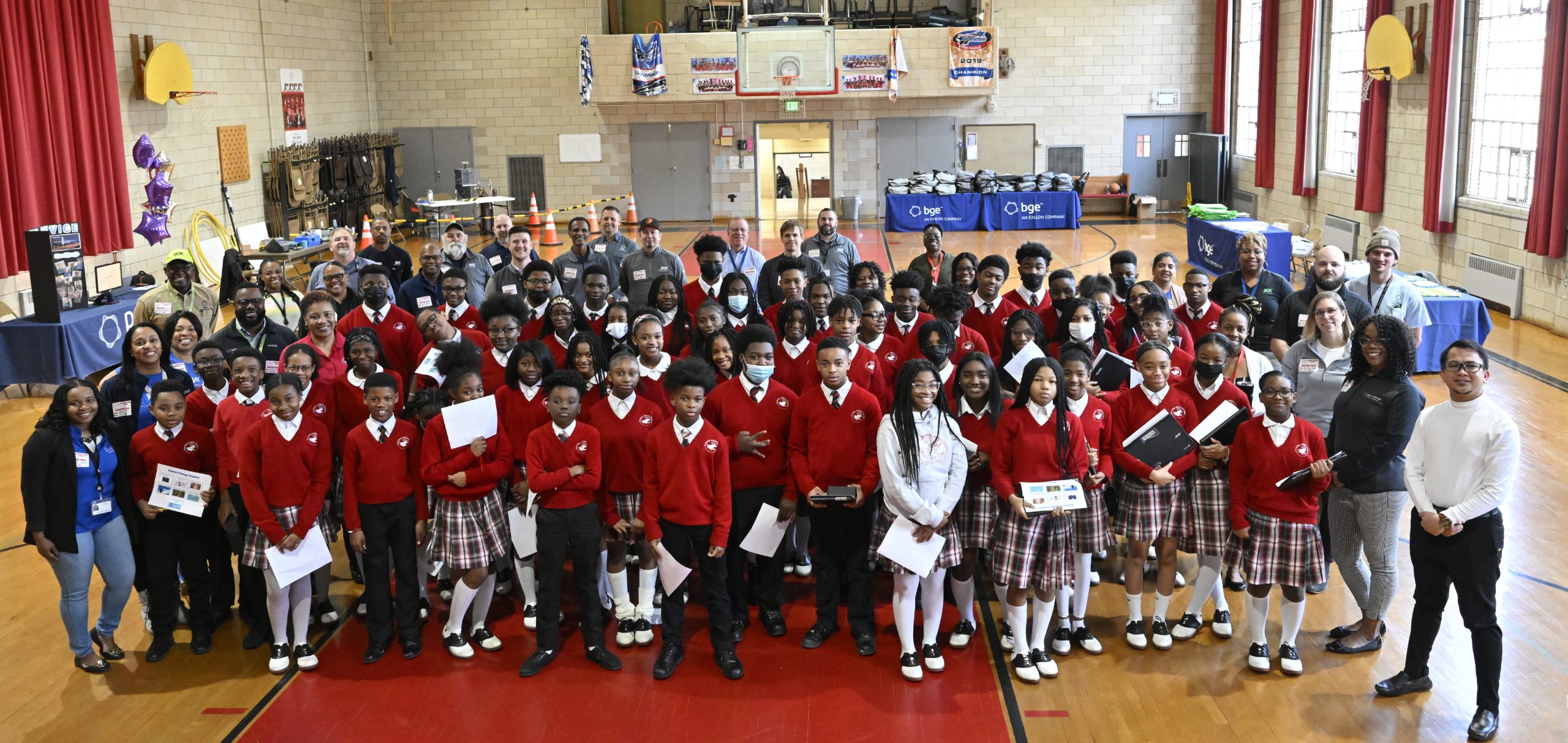 Students gather with BGE and PHI volunteers for group photo.