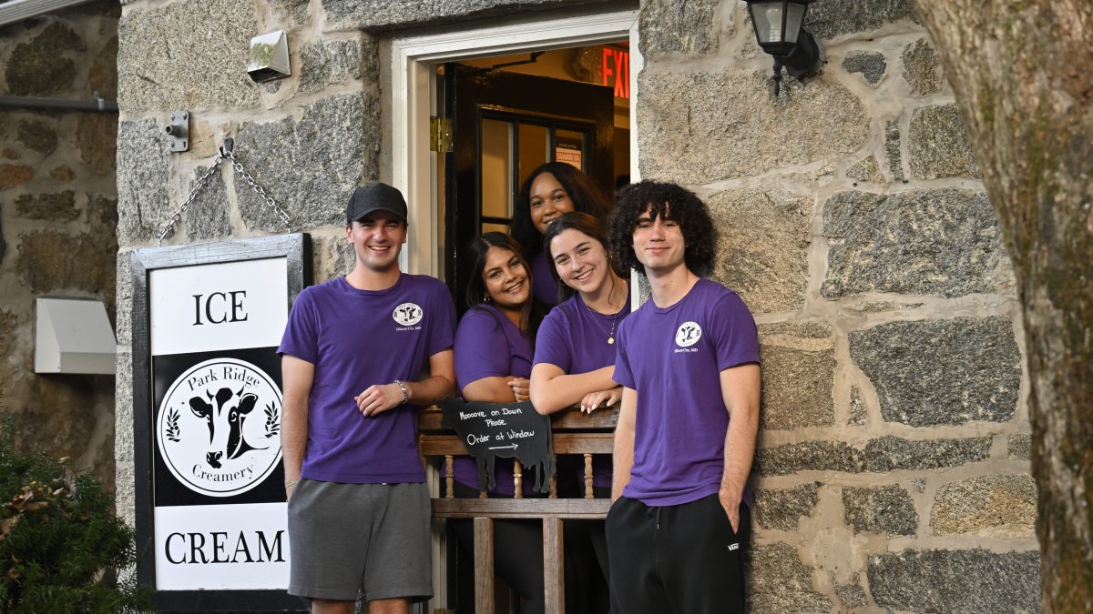Five employees of Park Ridge Creamery in purple branded T-shirts.