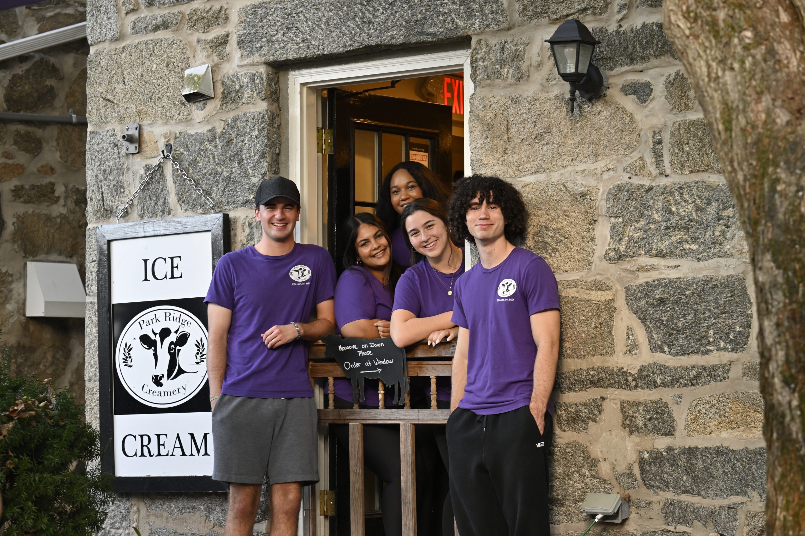 Five employees of Park Ridge Creamery in purple branded T-shirts.