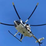 lineworker standing on side of a helicopter
