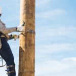 Lineworker climbing utility pole
