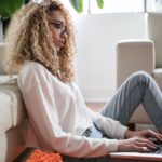 woman sitting on ground with laptop