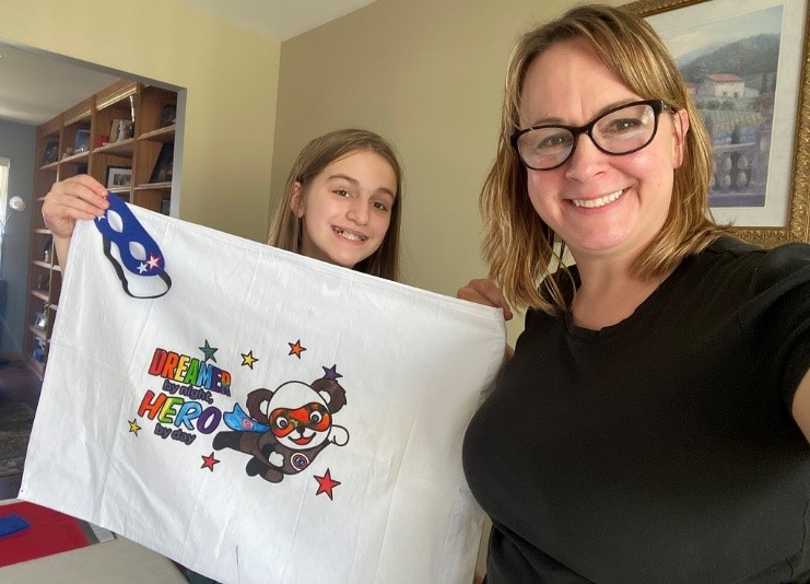 Angela Mosley, a ComEd supervisor in construction, along with her daughter, display one of the superhero pillowcases they created for foster children as part of The Safer at Home Superhero Project for National Volunteer Month.