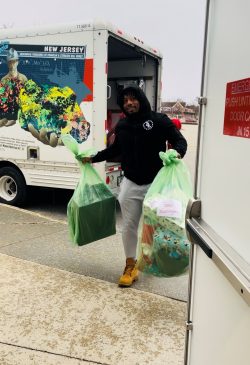 Shane at a volunteer event with bags full of holiday gifts to distribute to the children at Invisible Book Bag. 