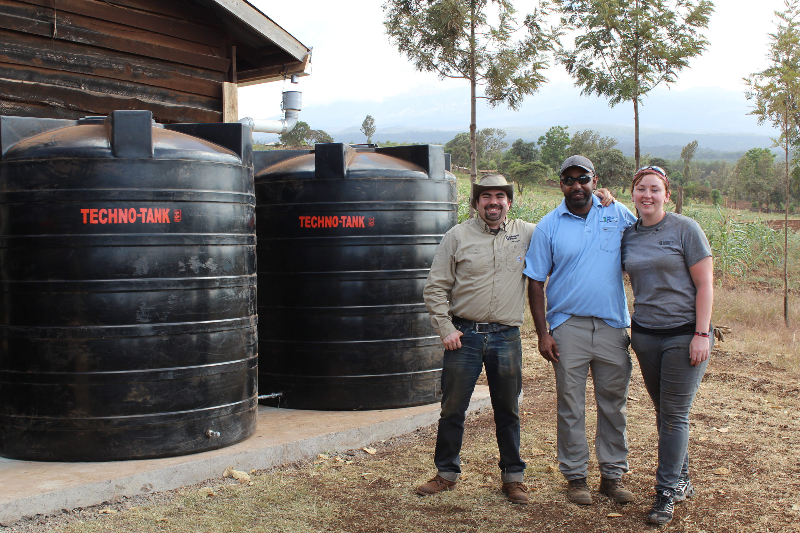 employees standing in front of water tank