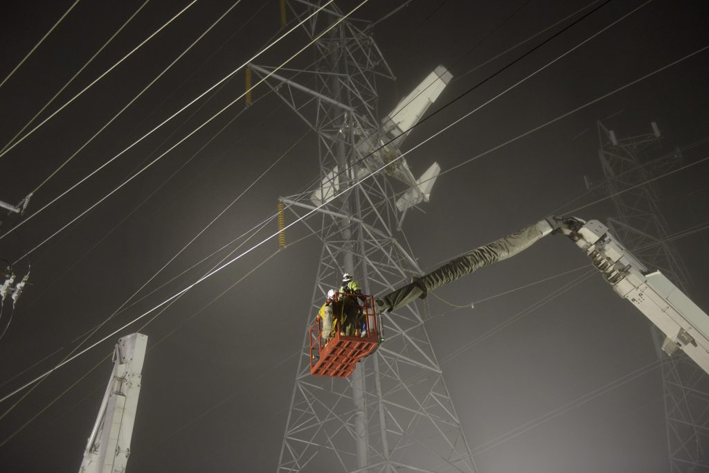 Emergency responders and aerial lineworkers ascend in a bucket to begin rescue mission